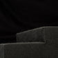 Un primo piano di schiuma grigio scuro con bordo smussato, su cui è visibile il “Subbox-Buz.2” di Gladen per il subwoofer della VW ID.Buzz, su sfondo nero.