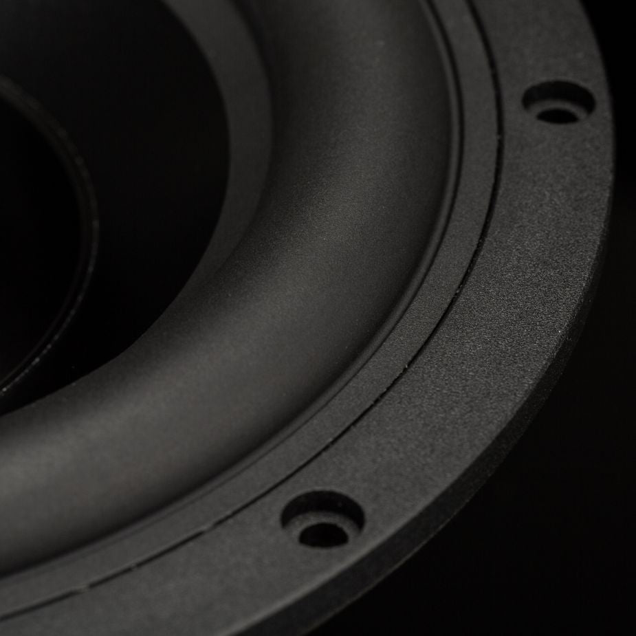 Primer plano del cono, el marco circular y los orificios de montaje del subwoofer Gladen Zeta 08: un potente subwoofer de Gladen que ofrece graves profundos sobre un fondo oscuro.