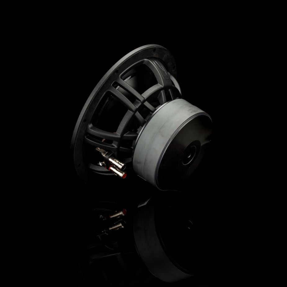 El Gladen Zeta 08 es un subwoofer negro de 8 con cableado y terminales a la vista, que ofrece unos graves potentes; se muestra de perfil sobre un fondo negro.