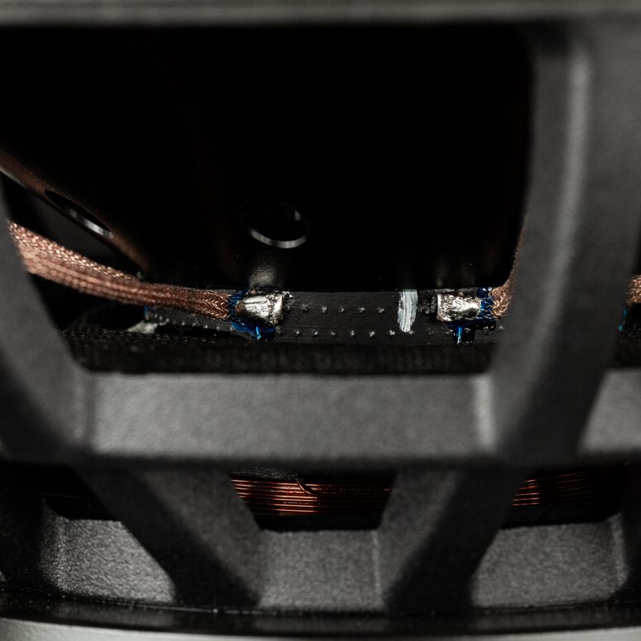 Primo piano degli interni del subwoofer Gladen Zeta 08, che mostra il cablaggio in rame e le parti metalliche che garantiscono bassi potenti e un suono dettagliato.
