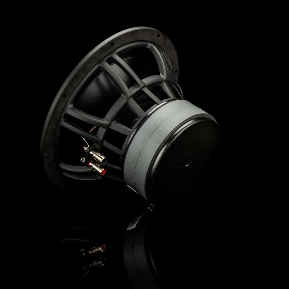 Il subwoofer Gladen Zeta 10 è raffigurato disteso su un lato davanti a uno sfondo nero intenso, il che ne mette particolarmente in risalto la potente resa dei bassi.