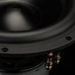 Primo piano del Gladen Zeta 10, un subwoofer nero da 10 che mostra il bordo, le viti e i terminali: ideale per bassi profondi su uno sfondo scuro.