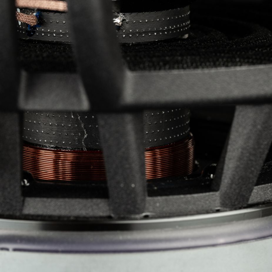 Primo piano di una bobina in rame incorniciata in nero, tratta dal Gladen Zeta 10, che mostra i materiali strutturati che garantiscono bassi potenti in un subwoofer da 10 pollici.