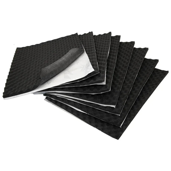 Several black, square Hifonics Zeus ZSQ15 panels with egg-crate texture are stacked, one corner peeled to show the self-adhesive, sound-absorbing backing.