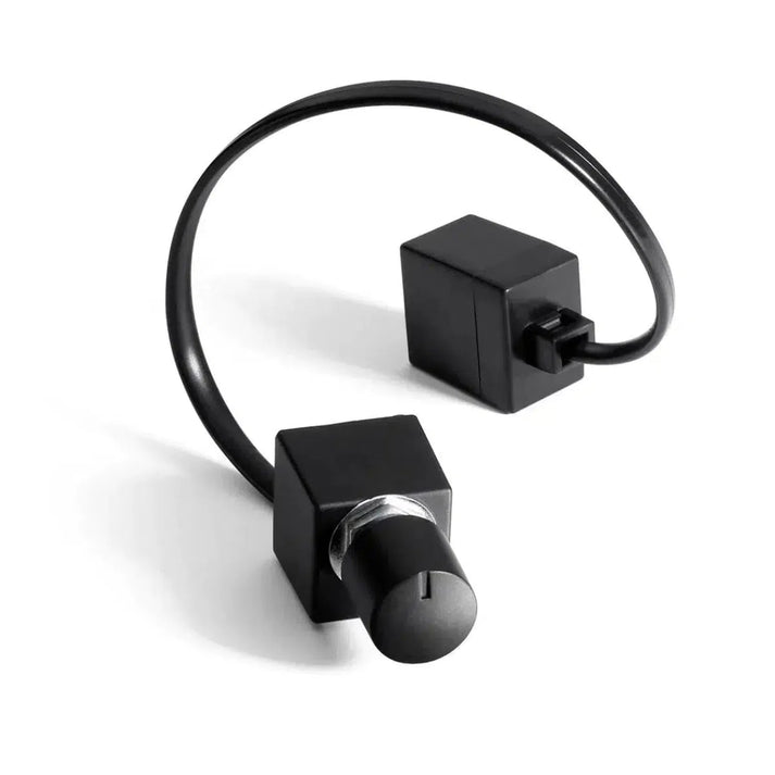 The JL Audio RBC-1 is a black bass control knob with cable and box, both square-shaped, shown on a white background.